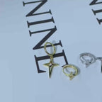 Un paio di orecchini asimmetrici in argento 925, di forma a stella a quattro punte liscia, adatti per uomo e donna per uso quotidiano casual, o come regalo per figlie e nipoti per le vacanze